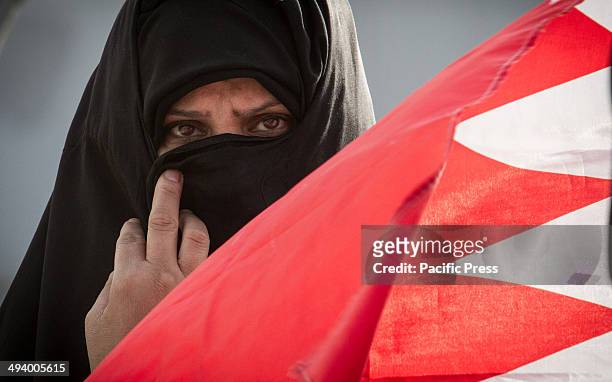 Bahraini woman carrying a Bahrain flag in front of the UN House. Citizens were taking part in a protest, in front of the UN building in Manama,...