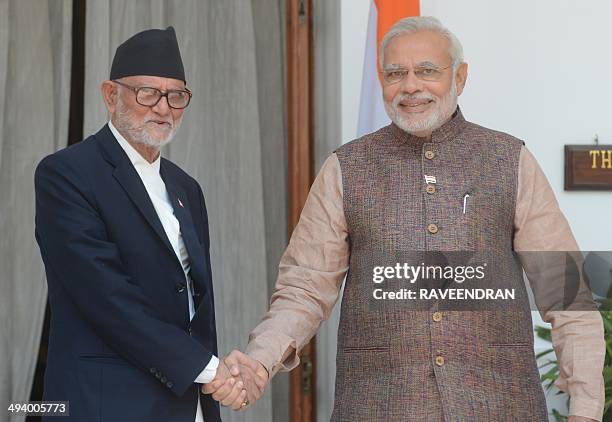 India's newly sworn-in Prime Minister Narendra Modi shakes hands with Nepalese Prime Minister Sushil Koirala during a meeting in New Delhi on May 27,...