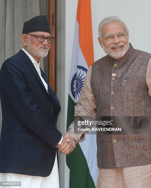 India's newly sworn-in Prime Minister Narendra Modi shakes hands with Nepalese Prime Minister Sushil Koirala during a meeting in New Delhi on May 27,...