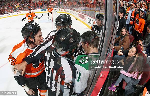 Linesmen Jay Sharrers and Derek Amell breaks up a scrum between Ryan White of the Philadelphia Flyers and Antoine Roussel of the Dallas Stars in NHL...