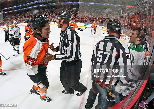 Linesmen Jay Sharrers and Derek Amell breaks up a scrum between Ryan White of the Philadelphia Flyers and Antoine Roussel of the Dallas Stars in NHL...