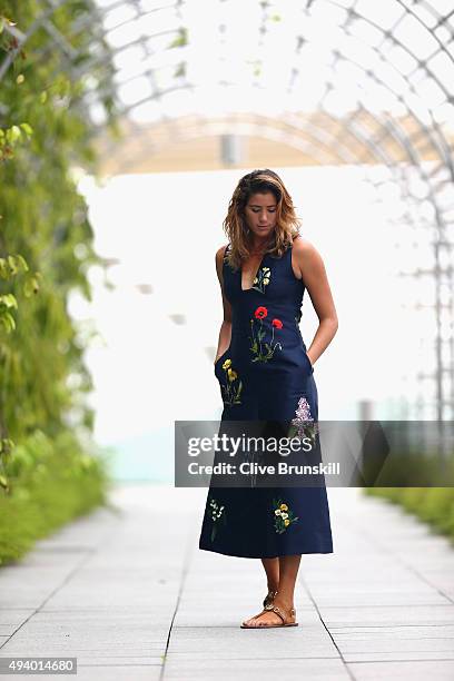 Garbine Muguruza of Spain poses for a photograph in her dress by Stella McCartney after talking to the media during previews for the WTA Finals at...