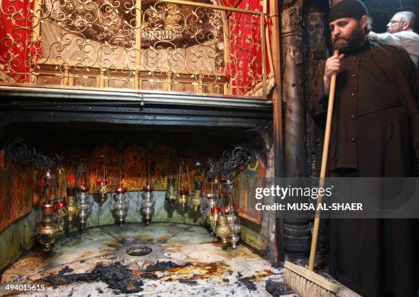 Priest prepares to clean the Grotto, at the Church of the Nativity, believed to be the birthplace of Jesus Christ, on May 27, 2014 after fire broke...