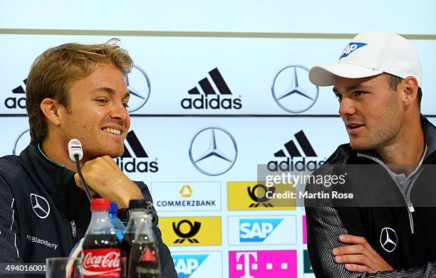 Formula 1 driver Nico Rosberg of Germany talks to golf professional Martin Kaymer of Germany during the German National team press conference on May...