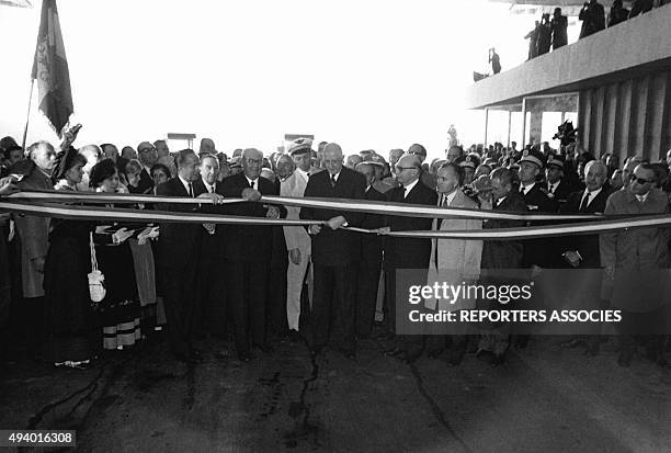 Le président de la République française Charles de Gaulle coupant un ruban lors d'une inauguration, en France.