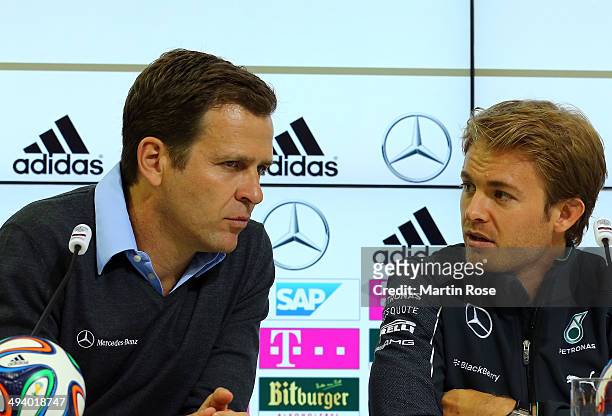 Team manager Oliver Bierhoff talks to Formula 1 driver Nicoe Rosberg of Germany during the German National team press conference on May 27, 2014 in...