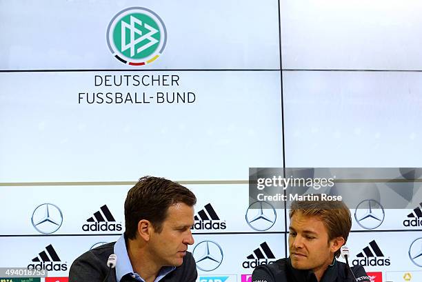 Team manager Oliver Bierhoff talks to Formula 1 driver Nicoe Rosberg of Germany during the German National team press conference on May 27, 2014 in...