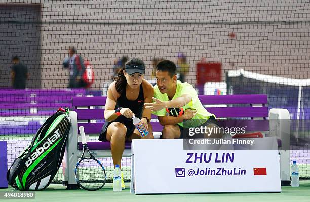 Zhu Lin of China talks to her coach during her round robin match against Naomi Osaka of Japan during the WTA Rising Stars Invitational at OCBC Arena...