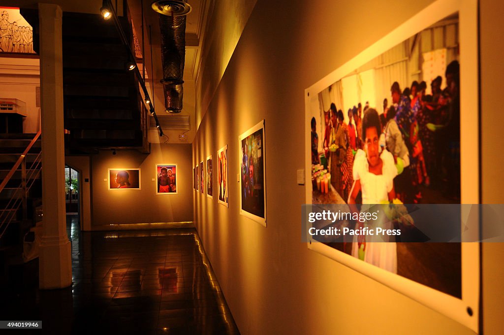 Visitors observe photographs by Shamow'el Rama Surya in...