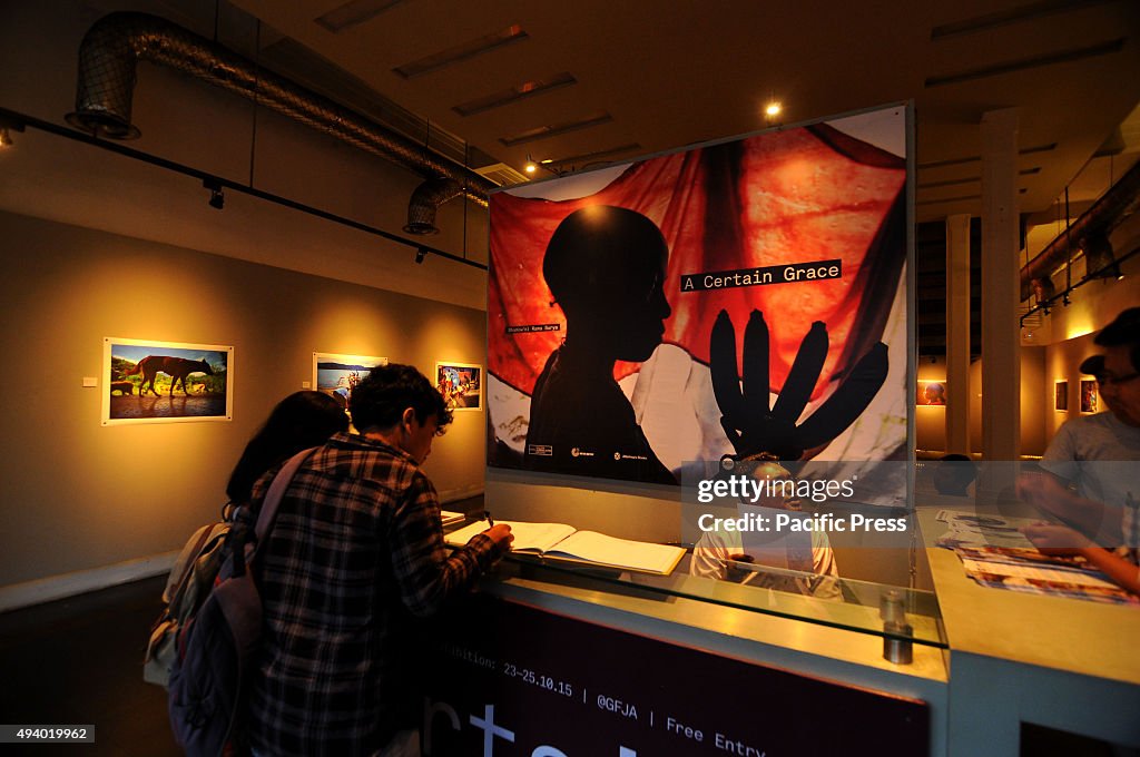 Visitors observe photographs by Shamow'el Rama Surya in...