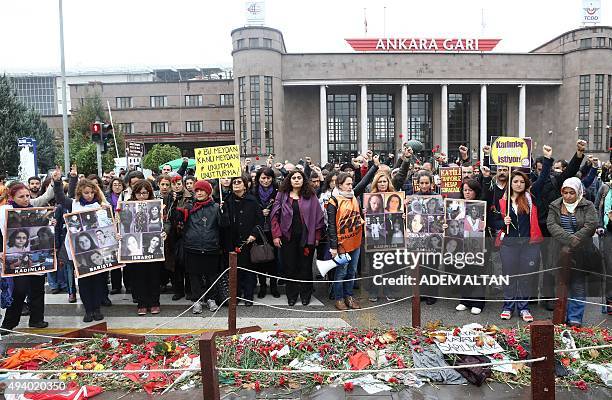 Mourners hold images of victims and banners reading 'women want peace' and 'we know the assassin,' as they gather at the site of twin explosions that...