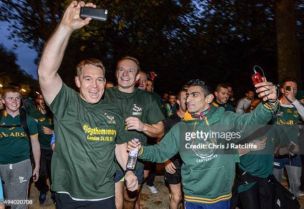 John Smit takes a photo of Captain Francois Pienaar as he leads the public and the 1995 South African Rugby World Cup winning squad on a run through...