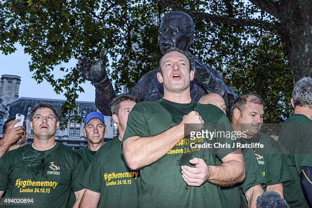 Captain Francois Pienaar and the 1995 South African Rugby World Cup winning squad lead fans in a rendition of their national anthem by a statue of...