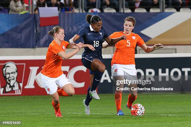 Marie-Laure Delie of France tries to control the ball against Mandy van den Berg and Dominique Janssen of Netherlands during the international...