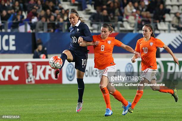 Camille Abily of France controls the ball against Sherida Spitse and Danielle van de Donk of Netherlands during the international friendly game...