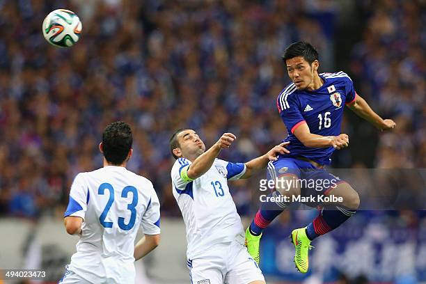 Hotaru Yamaguchi of Japan wins the ball over Konstantinos Makridis of Cyprus during the Kirin Challenge Cup international friendly match between...