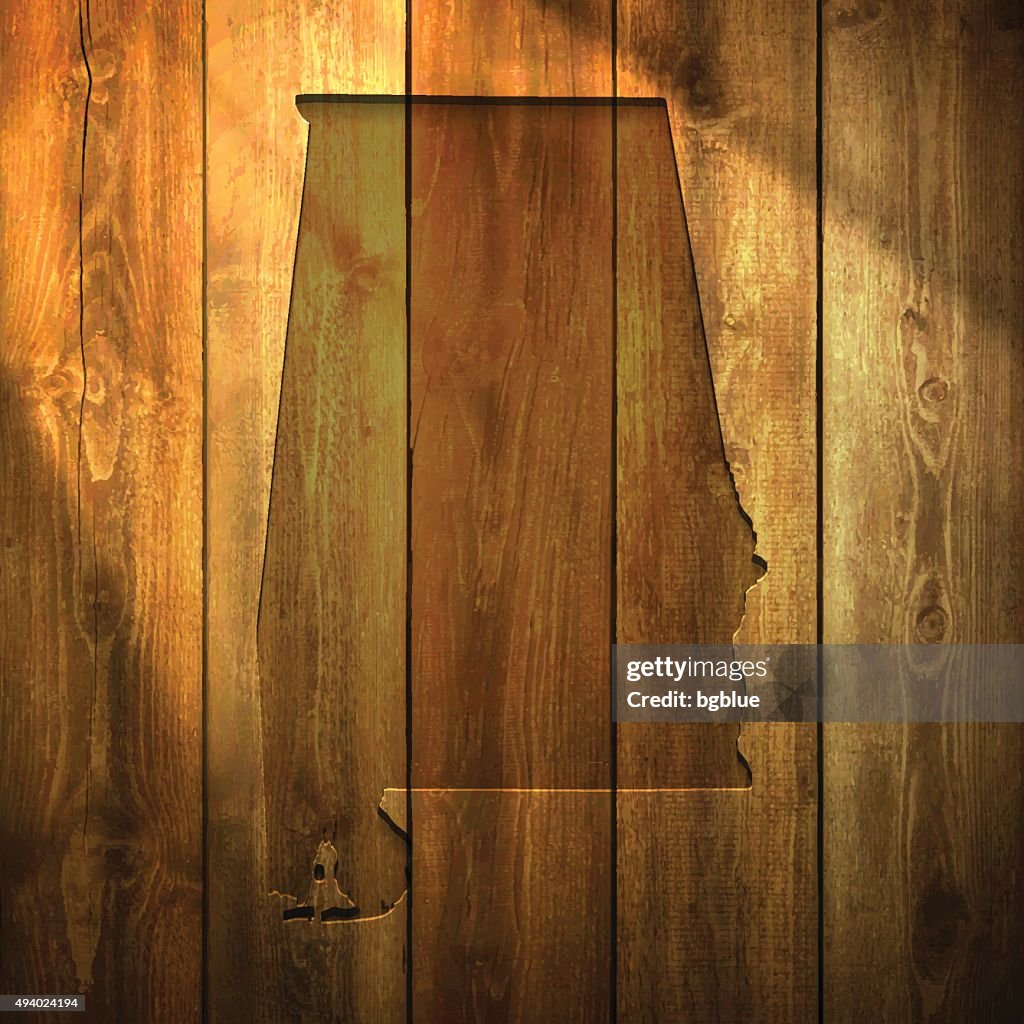 Alabama Map on lit Wooden Background