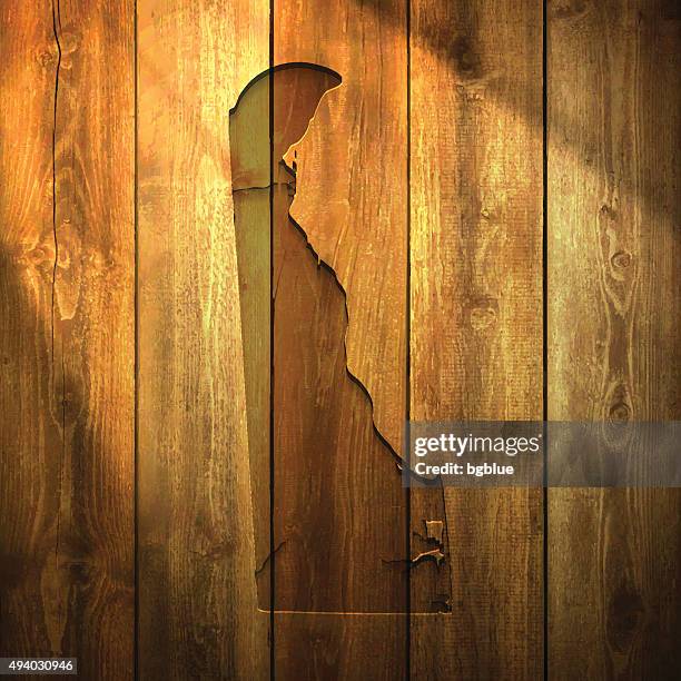 delaware map on lit wooden background - wilmington delaware stock illustrations