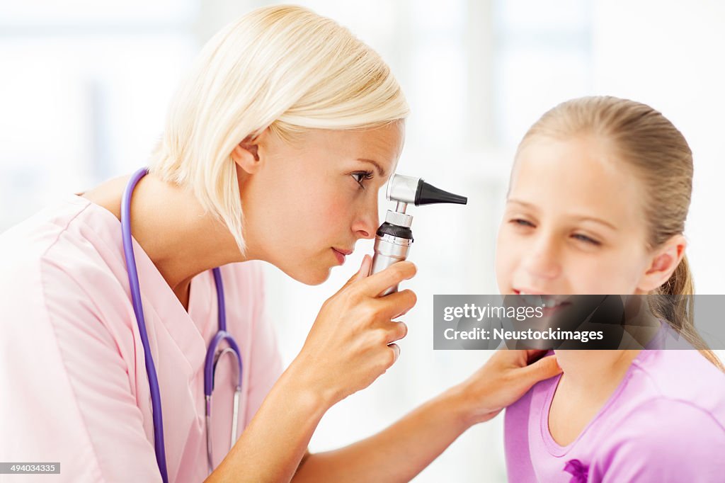 Doctor Examining Girl's Ear With Otoscope