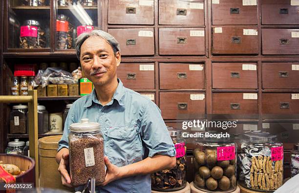 eigentümer der traditionellen chinesischen medizin shop in kowloon hongkong - chinese medicine stock-fotos und bilder