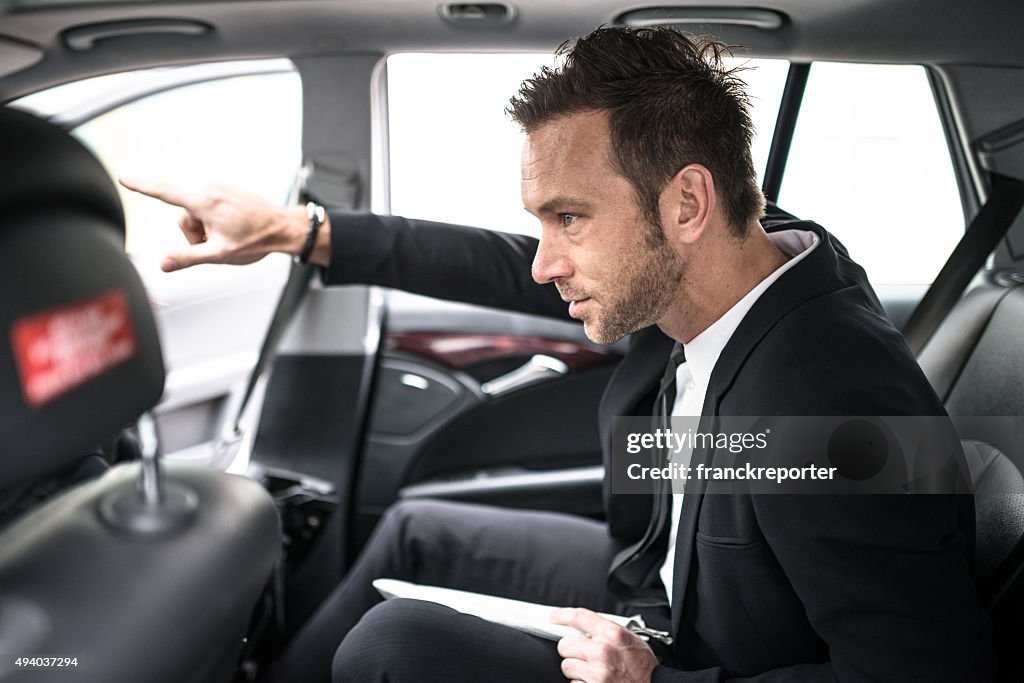 Businessman in the taxi car showing the route