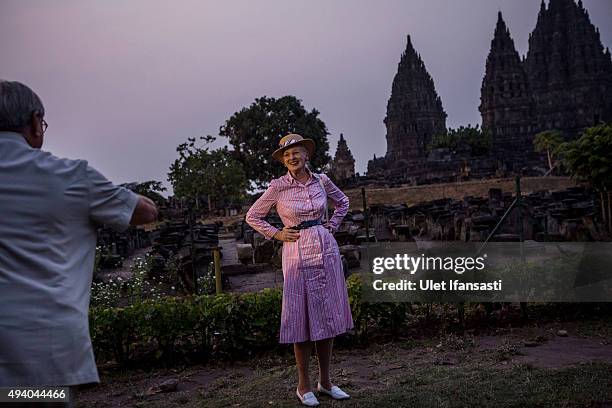 Queen Margrethe II of Denmark poses as her husband, Prince Henrik, takes her photograph during their visit at Prambanan temple on October 24, 2015 in...