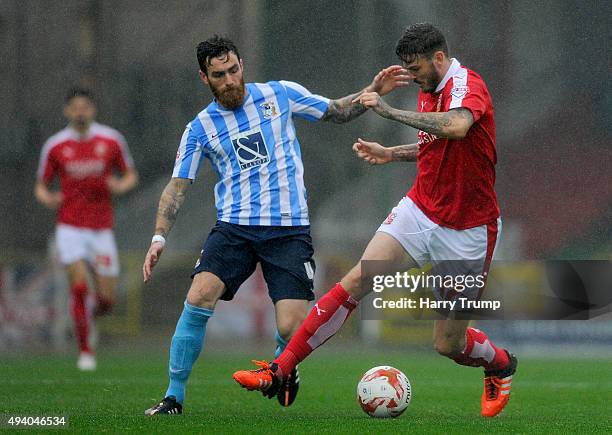 Ben Gladwin of Swindon Town is tackled by Romain Vincelot of Coventry City during the Sky Bet League One match between Swindon Town and Coventry City...