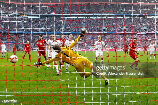 Robert Lewandowski of Muenchen scores the 3rd team goal against Timo Horn, keeper of Koeln during the Bundesliga match between FC Bayern Muenchen and...