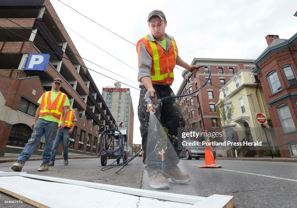 Brian James and a crew from L&D Street Markings paint crosswalks and directional signs