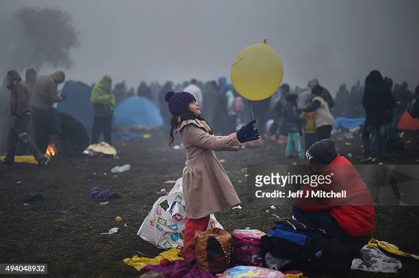 Migrants keep warm by fires as they are held back by the police near the village of Rigonce, before being walked to Brezice refugee camp on October...