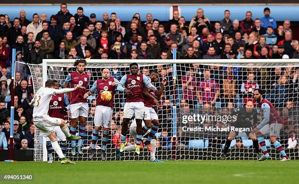 Gylfi Sigurdsson of Swansea City scores his team's first goal from a fee kick during the Barclays Premier League match between Aston Villa and...