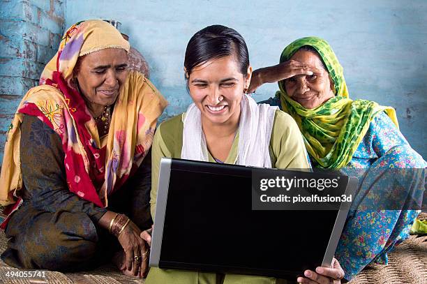 rural girl holding laptop with seniors - indian village people stock pictures, royalty-free photos & images