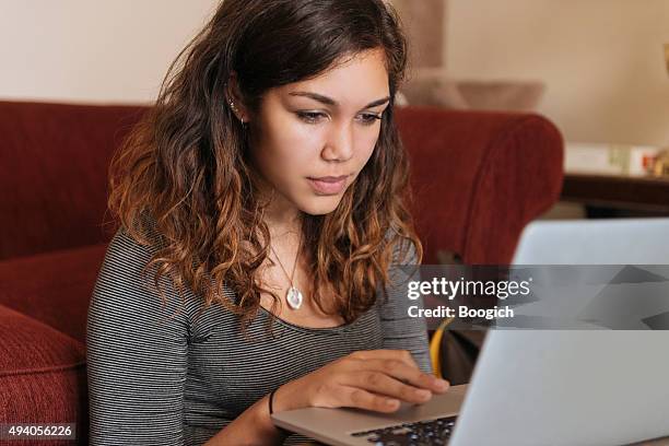 young woman studies on computer at home for higher education - puerto rican ethnicity stockfoto's en -beelden
