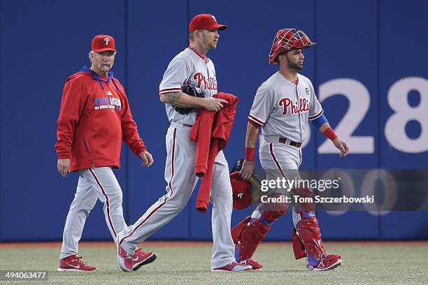 Burnett of the Philadelphia Phillies an Wil Nieves and pitching coach Bob McClure make their way from the bullpen to the dugout before the start of...