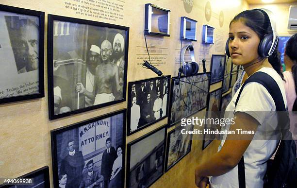 Girls listen to Mahatma Gandhi's speech inside mobile museum, showcasing some memories of Mahatma Gandhi in Government College for women in...