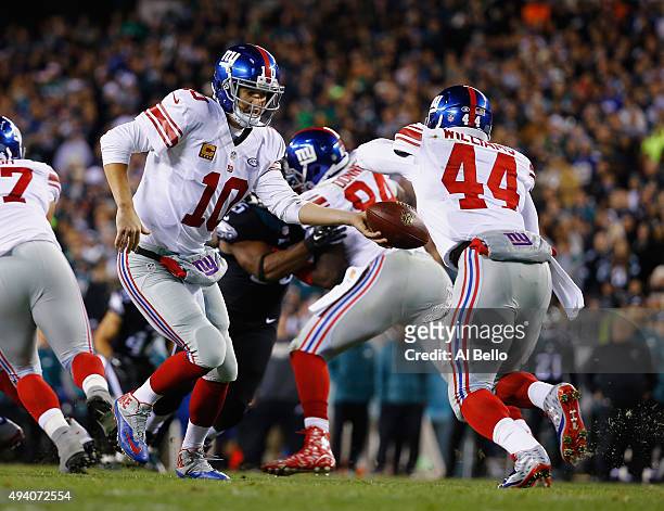 Eli Manning of the New York Giants hands off to Andre Williams against the Philadelphia Eagles during their game at Lincoln Financial Field on...