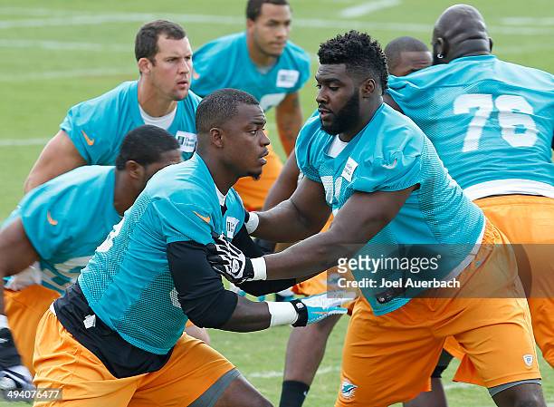 Dion Jordan and Terrence Fede of the Miami Dolphins participate in drills during the teams first OTA on May 27, 2014 at the Miami Dolphins training...