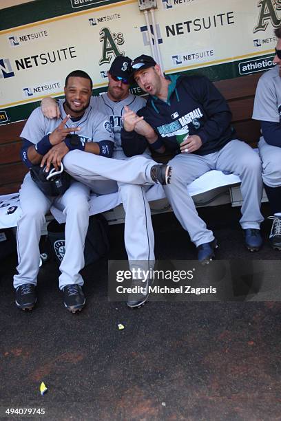 Robinson Cano, John Buck and Willie Bloomquist of the Seattle Mariners clown around in the dugout prior to the game against the Oakland Athletics at...