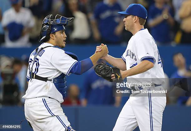 Casey Janssen of the Toronto Blue Jays celebrates their victory with Dioner Navarro during MLB game action against the Tampa Bay Rays on May 27, 2014...