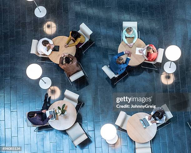 reunión de gente de negocios en las tablas, vista desde arriba - perspectiva extraña fotografías e imágenes de stock