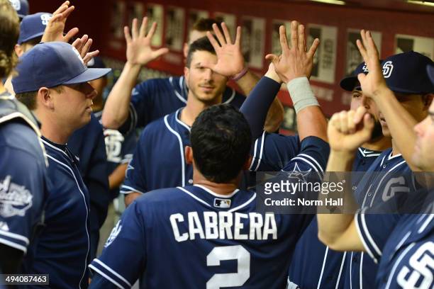 Everth Cabrera of the San Diego Padres and teammates celebrate scoring a run in the third inning against the Arizona Diamondbacks at Chase Field on...