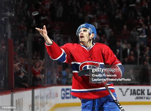 Rene Bourque of the Montreal Canadiens throws a puck in the crowd after recieving the first star of the game against the New York Rangers during Game...