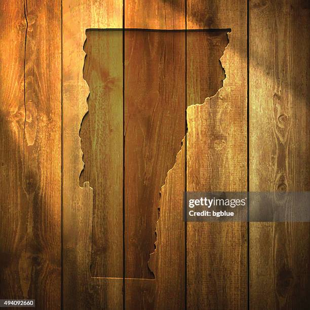 vermont map on lit wooden background - sunshine state stock illustrations