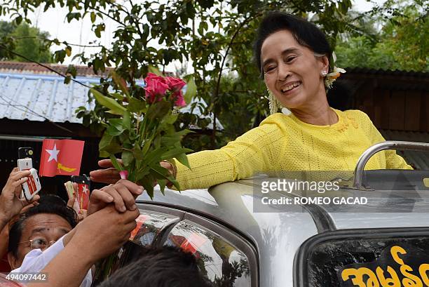 Myanmar opposition leader Aung San Suu Kyi receives roses from a supporter during a campaign rally for the National League for Democracy in Kawhmu on...
