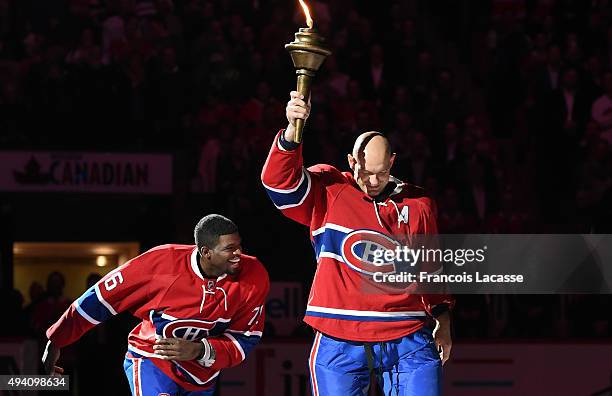 Subban hands over the flame to Andrei Markov of the Montreal Canadiens during the pre game ceremony prior to the NHL game against the New York...