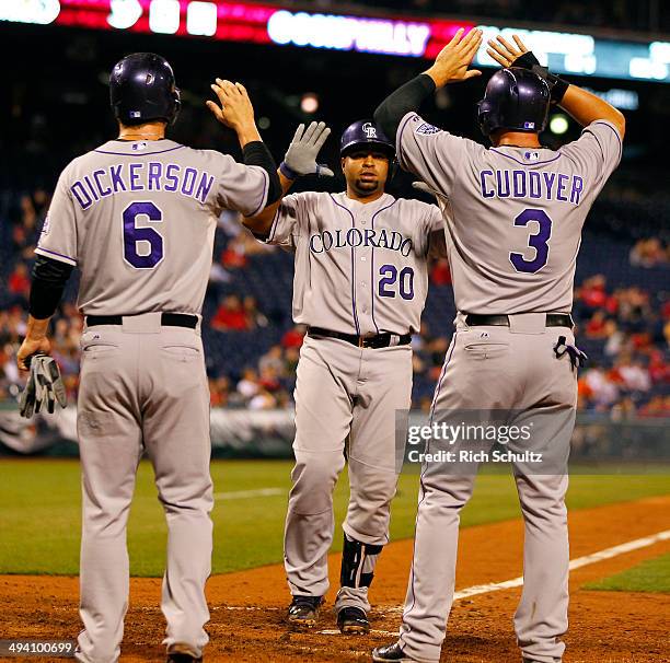 Wilin Rosario of the Colorado Rockies is congratulated by teammates Corey Dickerson and Michael Cuddyer after hitting a three-run home run during the...