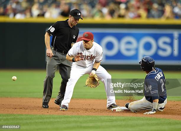 Cliff Pennington of the Arizona Diamondbacks gets ready to catch a bouncing ball as Everth Cabrera of the San Diego Padres slides safely into second...
