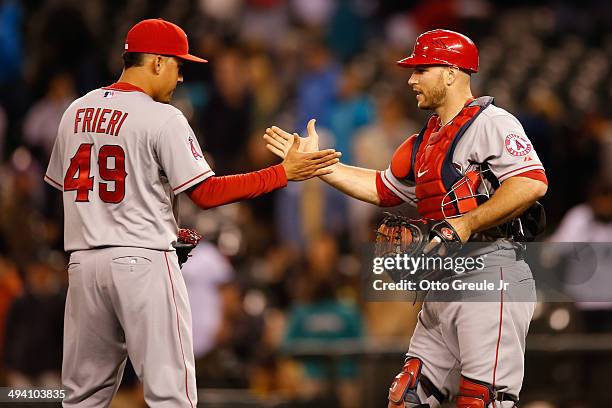 Closing pitcher Ernesto Frieri of the Los Angeles Angels of Anaheim celebrates with catcher Chris Iannetta after defeating the Seattle Mariners 6-4...