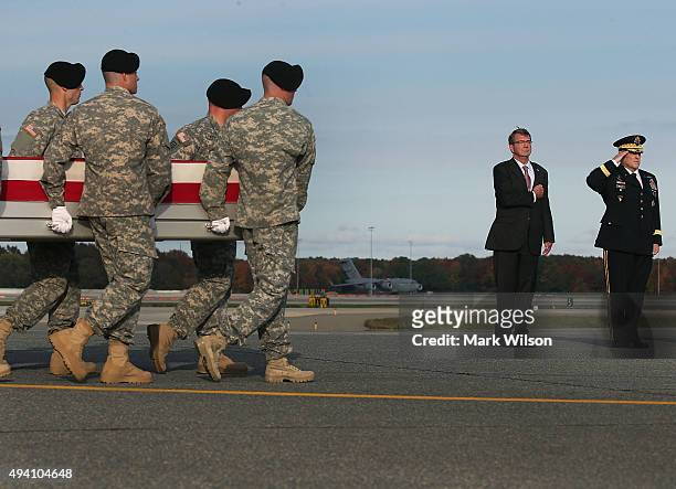 Secretary of Defense Ash Carter stands at attention with US Army Chief of Staff Gen. Mark Milley while a U.S. Army carry team moves the transfer case...