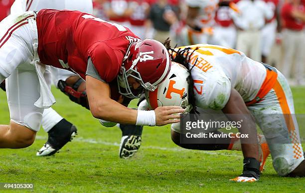 Jake Coker of the Alabama Crimson Tide rushes for more yardage as he charges into Jalen Reeves-Maybin of the Tennessee Volunteers at Bryant-Denny...